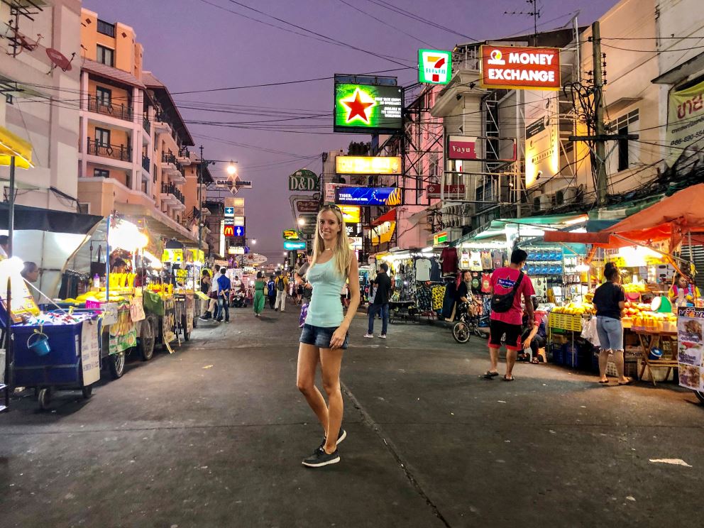 Bangkok Sehenswürdigkeiten, Frau steht bei Nacht in Khao San Road