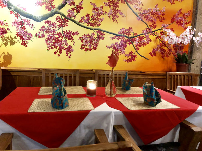 Restaurant mit roten Tischdecken und Blumen an der Wand