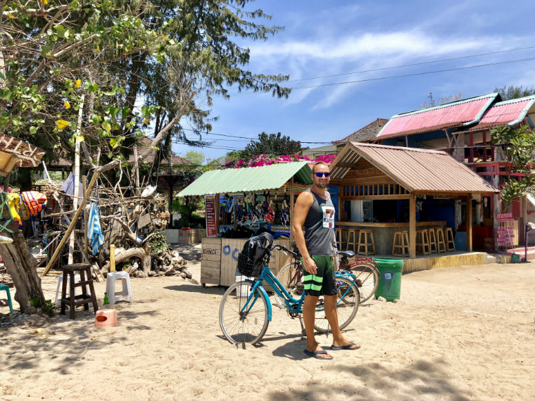 Mann vor Fahrrad am Strand