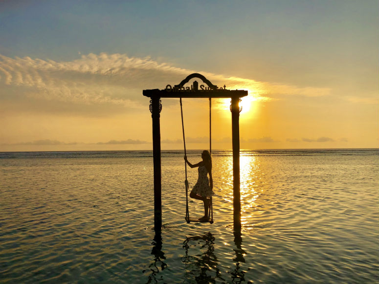 Frau auf Schaukel in Meer