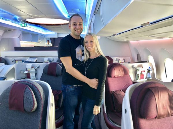 Mann und Frau stehen in Qatar Airways Business Class