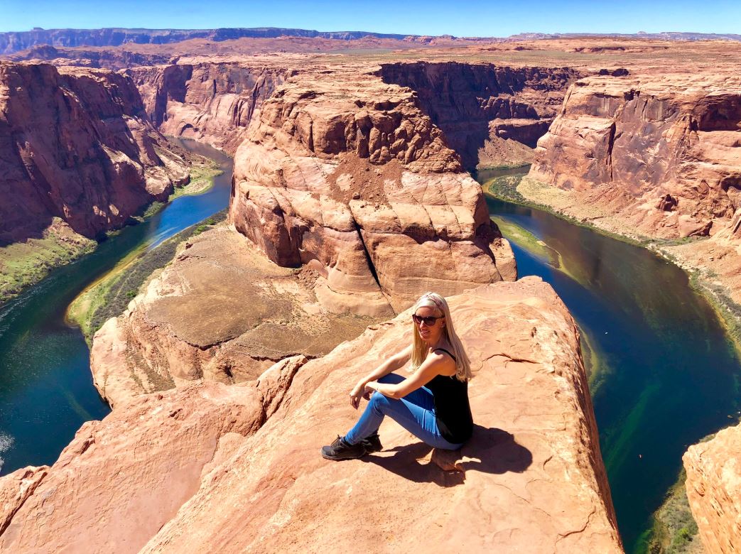 Frau sitzt auf Felsen am Horse Shoe Bend 