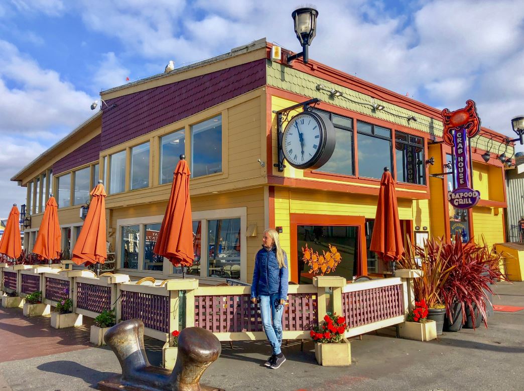 Frau vor buntem Haus im Fishermans Wharf in Monterey 