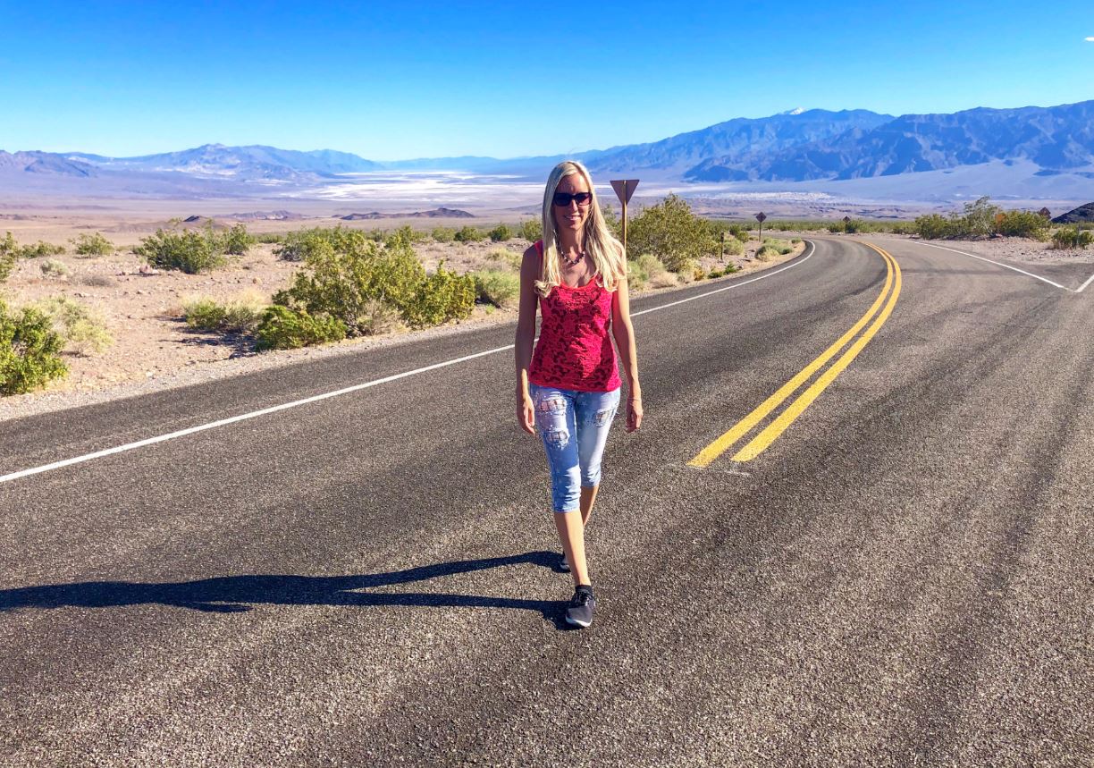 Nationalparks der USA, Frau steht auf Straße imDeath Valley