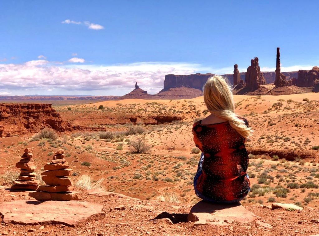 Sehenswürdigkeiten und Nationalparks der USA, Frau sitzt im Monument Valley