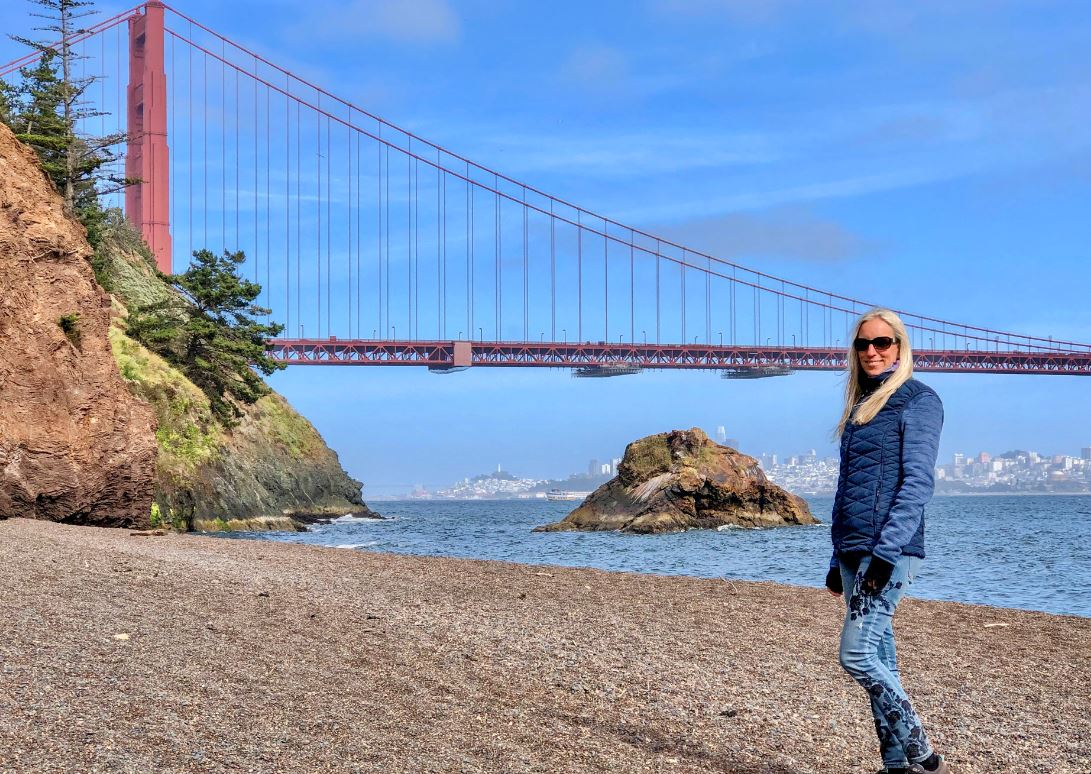 San Francisco Sehenswürdigkeiten, Frau am Strand vor Golden Gate Bridge