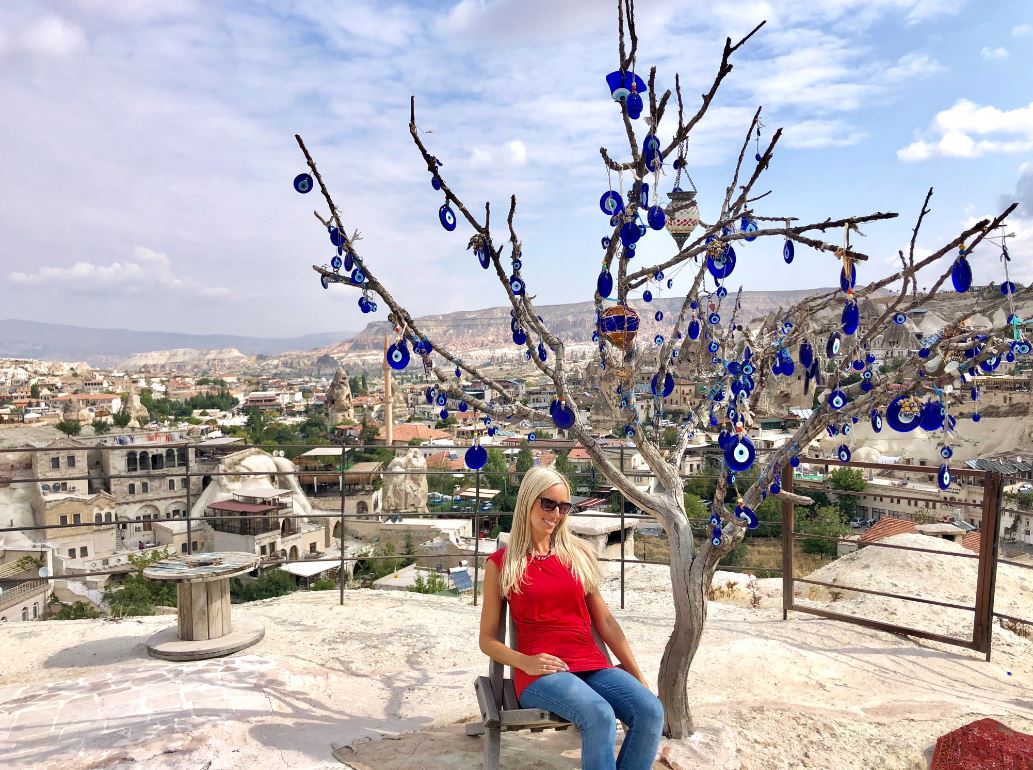 Göreme Kappadokien, Frau sitzt vor Baum mit türkischen Augen