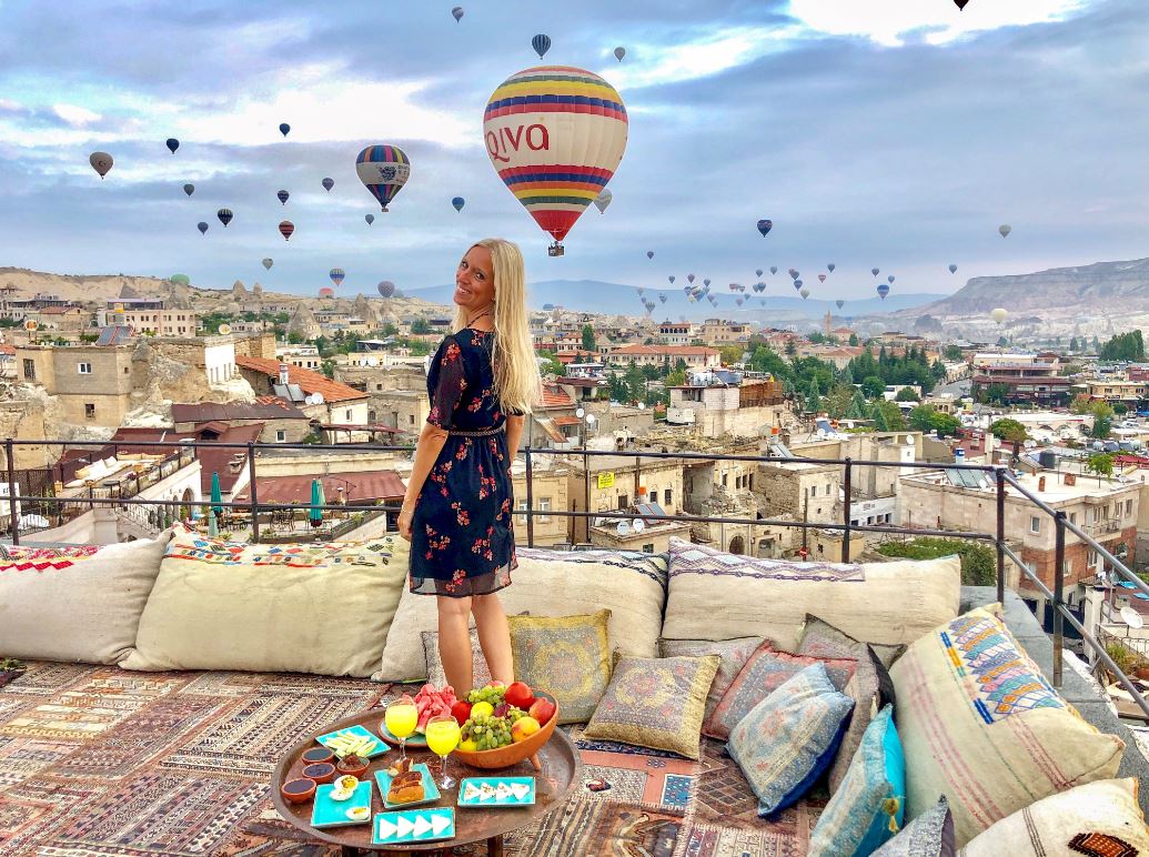 Kappadokien Reise, Frau auf Terrasse mit Ballons am Himmel