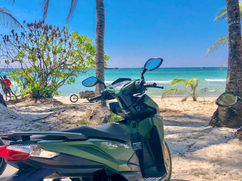 Rollerfahren auf Koh Chang, Roller steht am Strand vor türkisem Meer