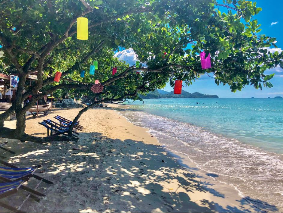 White Sand Beach Koh Chang, weißer Strand mit kleinen Liegestühlen und Lampions im Baum