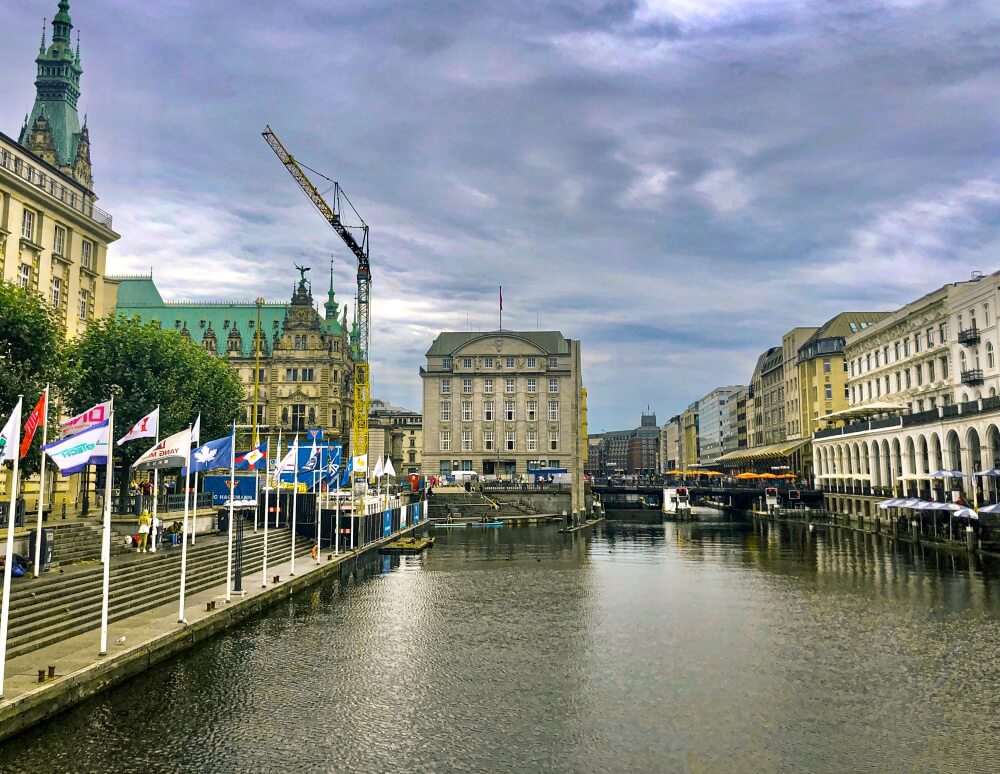 Der Jungfernstieg in Hamburg, Blick auf Wasser und Flaggen am Wegrand