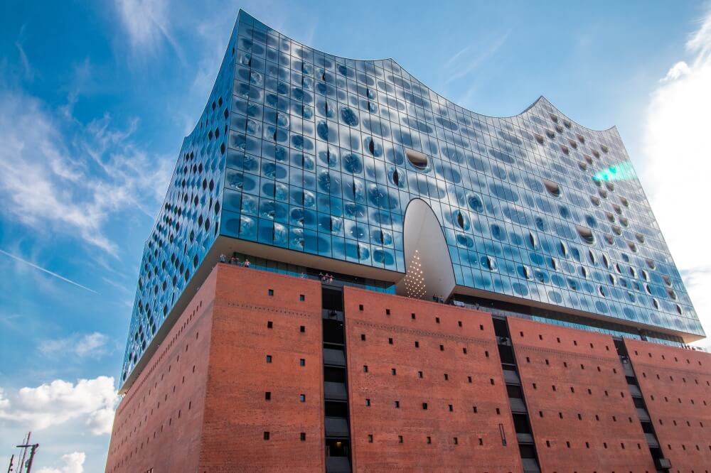 Blick von unten auf Elbphilharmonie mit großer Glaswand im oberen Bereich