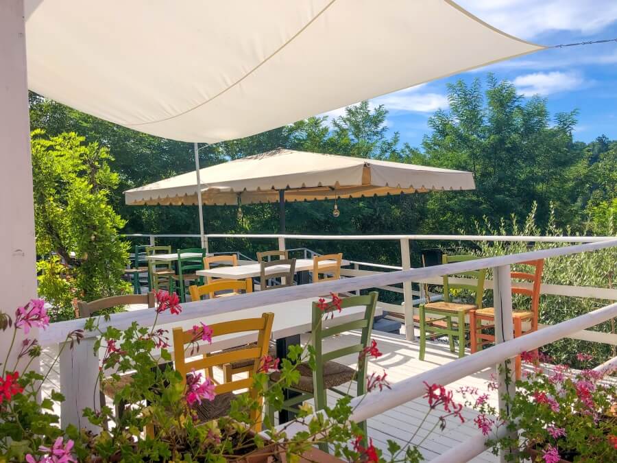 Agriturismo Villa Le Vigne, Bunte Holzstühle, weiße Tische auf Terrasse