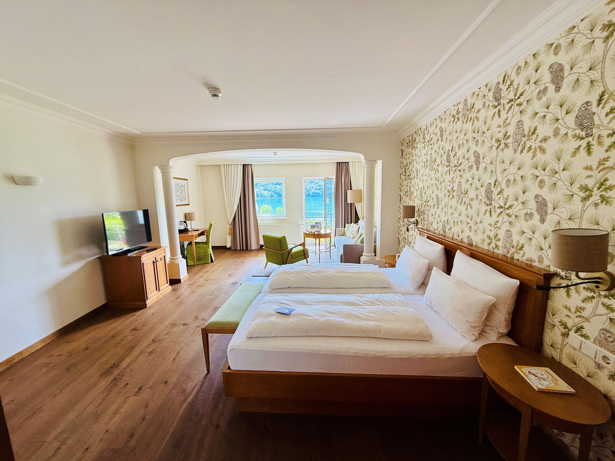 Waldhof Fuschlsee Resort Zimmer mit Blick auf Bett und Wohnbereich