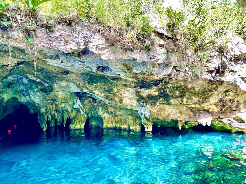 Blick auf Höhle mit kristallklarem, blauen Wasser