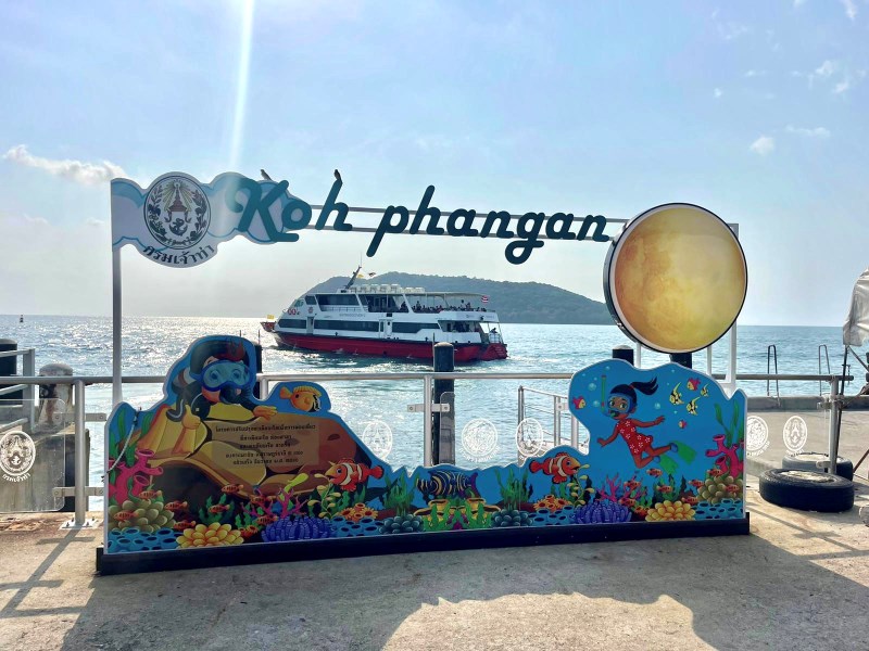 Pier mit Koh Phangan Schild und Boot im Hintergrund