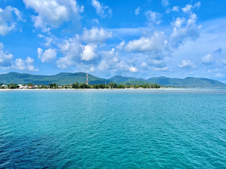 Blick auf Meer vom Boot aus mit Insel im Hintergrund