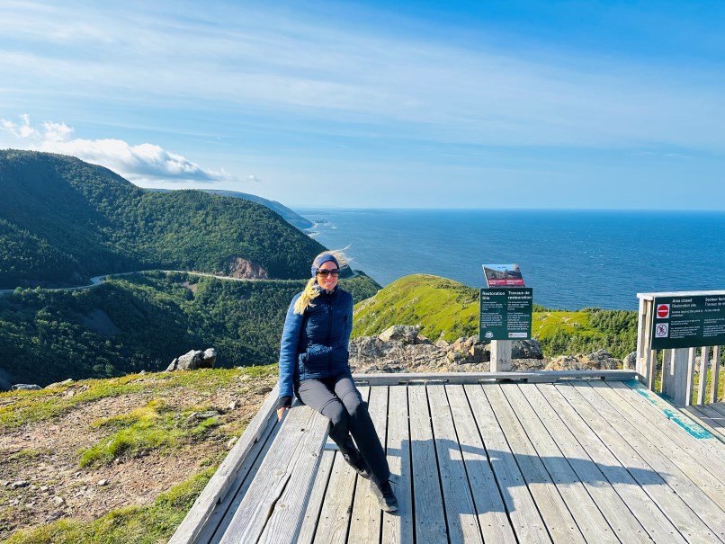 Cabot Trail, Frau mit Küste im Hintergrund und durch den Wind wehende Haare