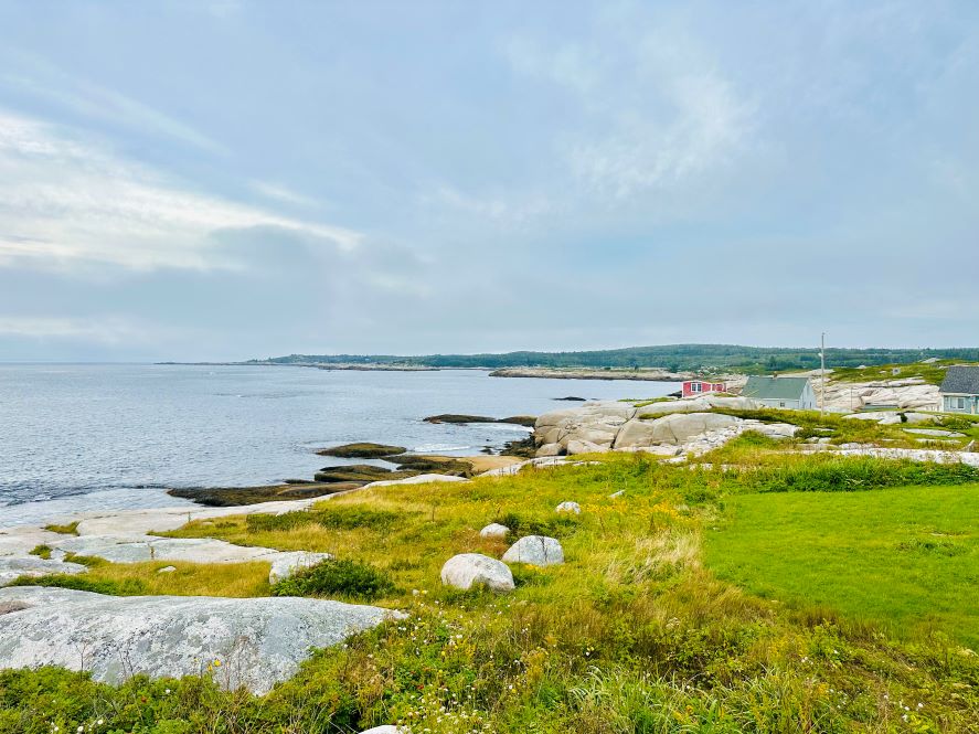 Blick über die Bucht in Peggys Cove mit grünem Rasen und Wasser