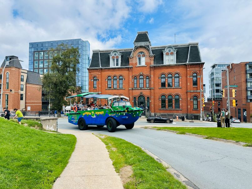 Halifax Sehenswürdigkeiten Harbour Hopper Tours Fahrzeug, das sowohl an Land als auch auf dem Wasser fahren kann fährt an Gebäude vorbei