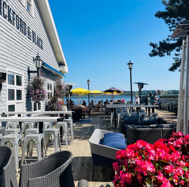 Halifax Sehenswürdigkeiten, Waterfront, Restaurant mit Blick aufs Wasser, rote Blumen im Vordergrund