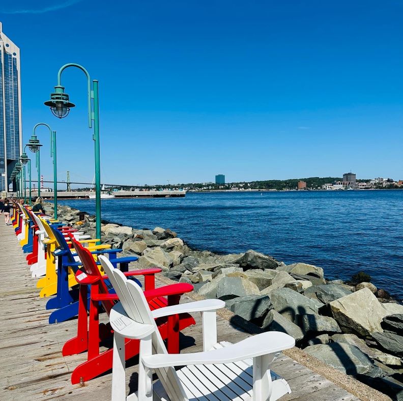 Halifax Sehenswürdigkeiten Waterfront, bunte, für Kanada typische Stühle aus Holz direkt am Wasser