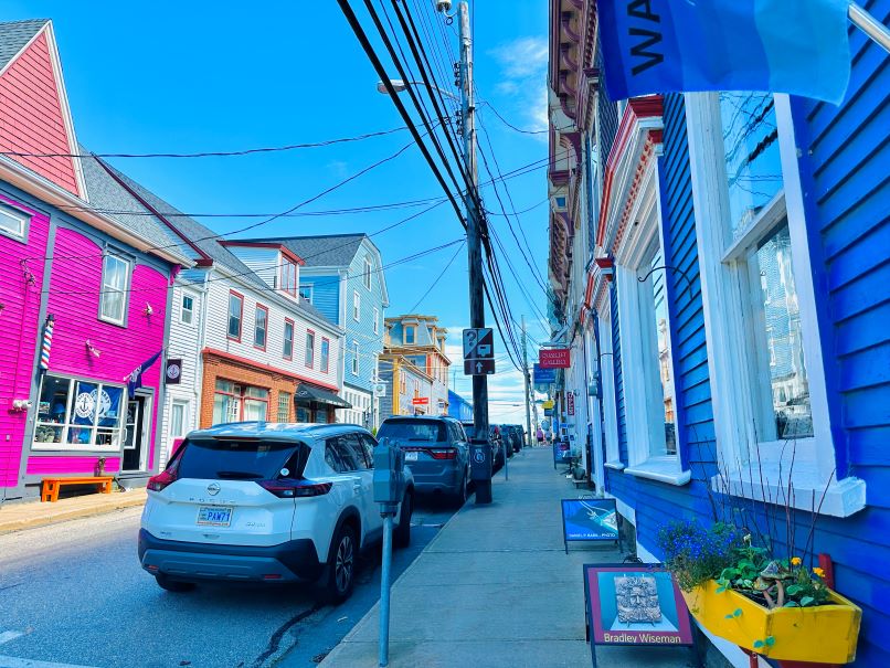 Autos zwischen Häusern in pinken, blauen und weißen Farben in Lunenburg