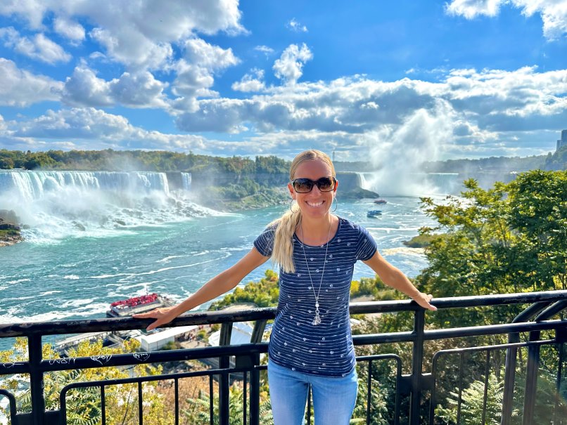 Frau steht an Geländer vor Niagarafälle