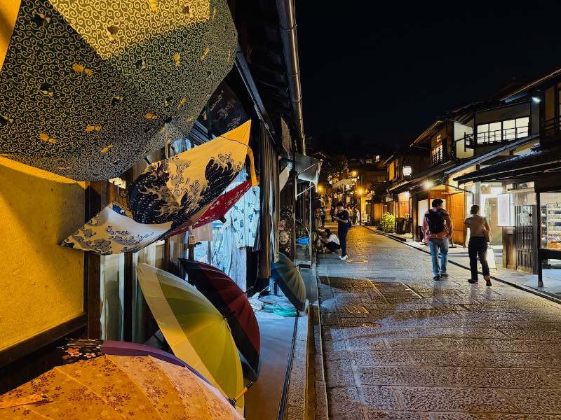 Gion in Kyoto bei Nacht. Bunte Schirme, schmale Gassen, Holzhäuser